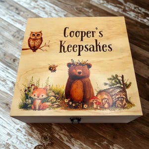 May include: Wooden keepsake box with a woodland scene featuring a bear, fox, owl, and bee. The box is decorated with a nature-themed illustration and the text "Cooper's Keepsakes" on the lid.