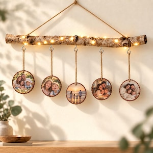 Personalisierter Birken-Deko-Ast mit fünf Familienfotos, Baumscheiben und warmer LED-Lichterkette.