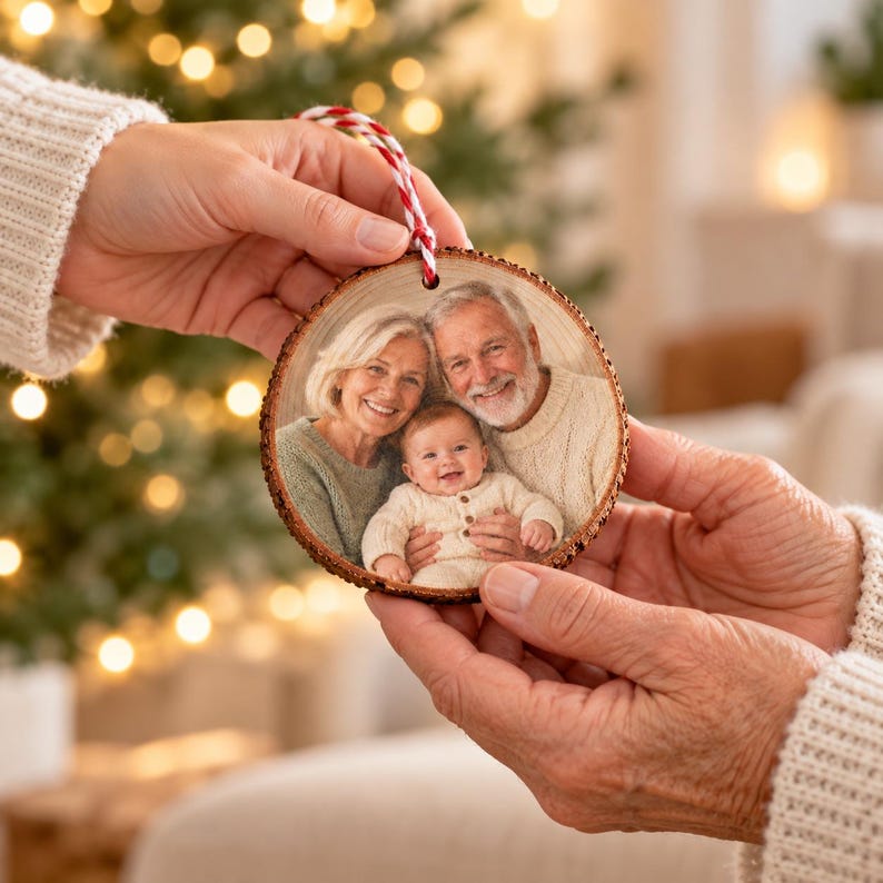 Geschenkübergabe des Foto von Oma, Opa und Enkelkind-Anhängers an eine frischgebackene Oma, mit glaubwürdigem Handmaßstab und sichtbarem Foto von Oma, Opa und Enkelkind.