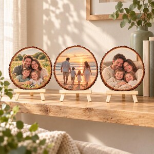 Wohnbeispiel: drei personalisierte Familienfotobaumscheiben als kleine Galerie auf einem Regal.