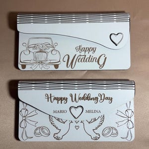 Puede incluir: Dos tarjeteros de boda de madera blanca. Uno presenta un coche antiguo con flores y la frase "Happy Wedding". El otro tiene "Happy Wedding Day", nombres, palomas, anillos y corazones.