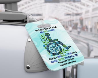 Könnte beinhalten: Ein hellblaues Gepäckanhänger mit dem Text "PLEASE TREAT AS A WHEELCHAIR" und einer Rollstuhl-Grafik. Das Etikett enthält auch den Text "This is a WHEELCHAIR for a CHILD WITH DISABILITIES Please Be Patient Handle with Care."