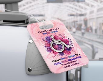 Könnte beinhalten: Rosa Gepäckanhänger mit einem Rollstuhlsymbol und dem Text "PLEASE TREAT AS A WHEELCHAIR This is a WHEELCHAIR for a CHILD WITH DISABILITIES Please Be Patient Handle with Care"