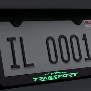 Moldura de placa de licença TrailSport brilhante em metal preto com parafusos e tampas