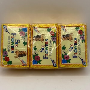 May include: Three bars of yellow soap with a floral design and the words "Six Flowers Toilet Soap" printed on each bar.