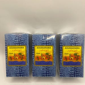 Puede incluir: Tres cajas azules y doradas con un patr&oacute;n de piel de cocodrilo. Cada caja contiene un frasco de 30 ml de perfume Aoussarabia. Las cajas tienen texto &aacute;rabe y las palabras "Aoussarabia" y "30 ml" impresas en ellas.