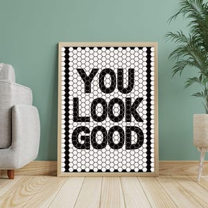 May include: A white ceramic mug with a black handle and the text "But First, Coffee" in a bold, black font. The mug is set against a blurred background, suggesting a cozy setting.