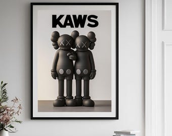 May include: Framed art print featuring two black figures with X-shaped eyes and button-like bellies, standing side-by-side. The word "KAWS" is printed in bold black letters above the figures. The artwork is displayed in a black frame.