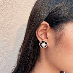 Pendientes chapados en oro de 14 quilates. Diseñados en una elegante forma de camelia, microengastados con brillantes circonitas cúbicas AAA+.