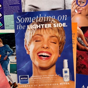 K&ouml;nnte beinhalten: Zeitschriftenwerbung mit einer lachenden Frau mit blonden Haaren. Die &Uuml;berschrift lautet "Something on the Lighter Side". Eine Flasche Nivea Visage No Oil All Moisture Hydrogel ist zu sehen. Die Werbung bewirbt Nivea als Europas Nr. 1 Feuchtigkeitspflege.