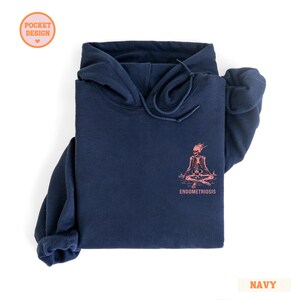 hooded sweatshirt in color navy. Pocket design: Pink skeleton with the text Endometriosis in grunge distressed font in pink