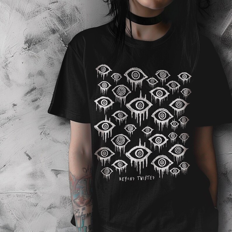 May include: Black t-shirt featuring a white graphic print of repeating stylised eyes with dripping lines. The text "Beyond Twisted" is printed below the graphic.