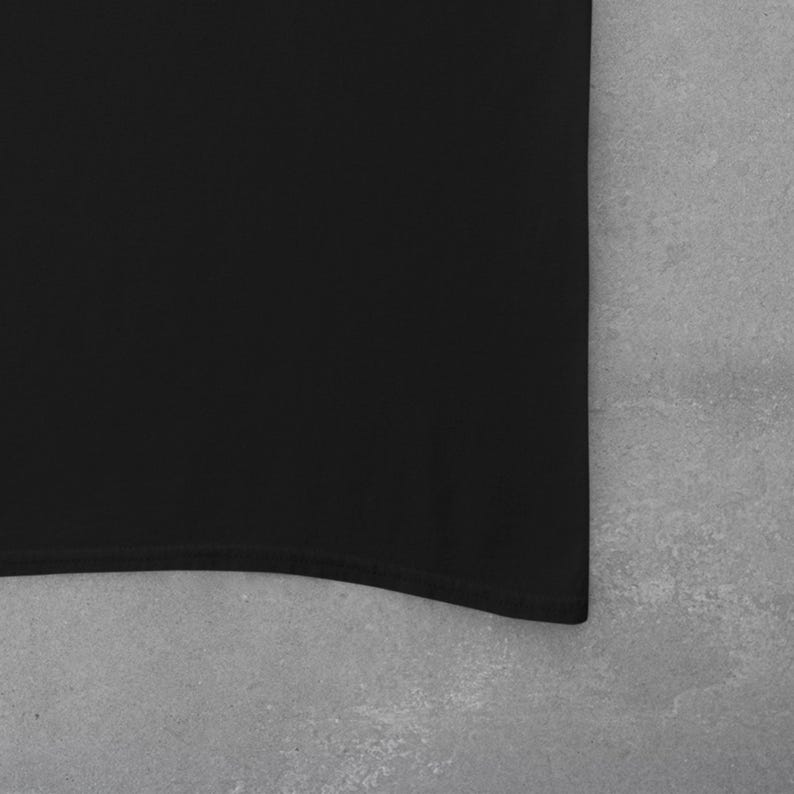 May include: A black, plain, cotton t-shirt with a curved hem.
