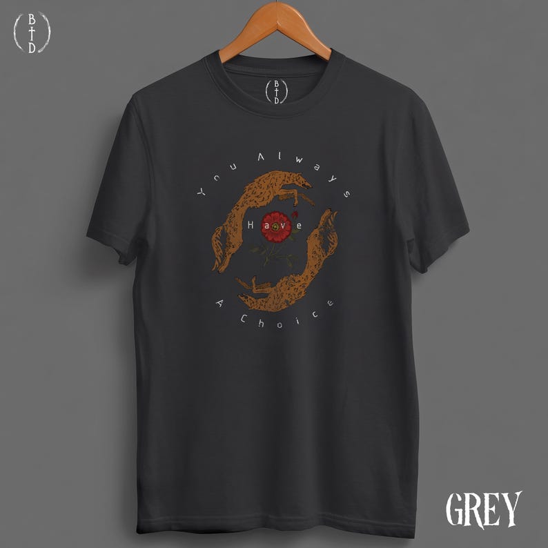 May include: Dark grey t-shirt with a circular graphic featuring two stylized cheetahs and a red flower. The text "You always have a choice" surrounds the design. The shirt has short sleeves and a crew neck.