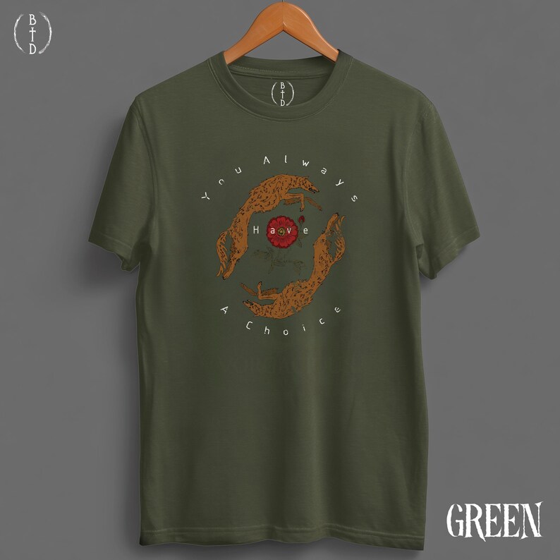 May include: Olive green t-shirt with a circular graphic featuring two cheetahs and the text "You always have a choice." The graphic is in shades of brown and red. The word "GREEN" is printed in white at the bottom right.
