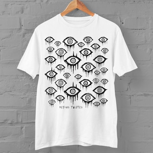 May include: White t-shirt featuring a black and white print of numerous eyes with spirals. The text "Beyond Twisted" is printed at the bottom of the shirt.