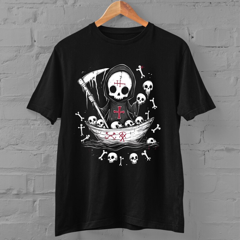 May include: Black t-shirt with a graphic of a skeleton wearing a hooded robe and holding a scythe. The skeleton is in a boat with skulls and bones around it. The text "X" is on the boat.