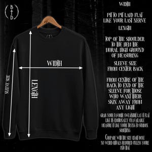 May include: A black crewneck sweatshirt on a hanger with white measurement lines and text overlay. The text includes instructions like Width, Length, and Sleeve Size, along with humorous phrases about measuring and summoning something.