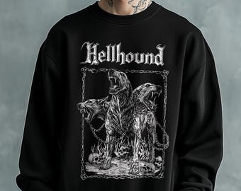 May include: A black crewneck sweatshirt featuring a white graphic print of a three-headed dog surrounded by chains and skulls. The text Hellhound is printed in a stylized gothic font above the central illustration of the snarling canine.