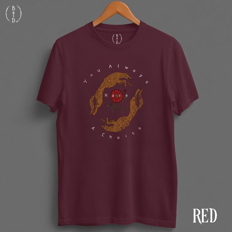 May include: A maroon t-shirt with a graphic design featuring two stylized hands encircling a red rose. The text "You always have a choice" is printed around the hands. The word "RED" is printed in the bottom right corner.