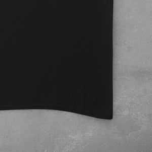 Op de afbeelding: Een zwart, effen katoenen T-shirt met een gebogen zoom.