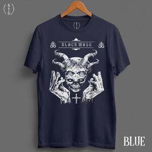 May include: A dark blue short-sleeve t-shirt featuring a white graphic print of a horned skull with hands raised on either side. The text "BLACK MASS" is printed above the skull, flanked by two Leviathan cross symbols and a small cross below.