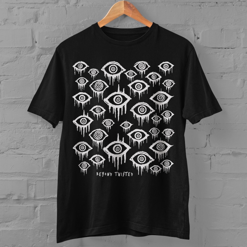 May include: Black t-shirt featuring a white print of numerous stylised eyes with swirling patterns. The text "Beyond Twisted" is printed at the bottom of the shirt.