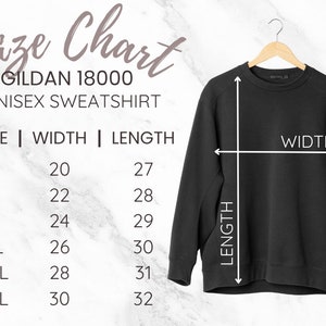 May include: A black Gildan 18000 unisex sweatshirt hanging on a wooden hanger. The image includes a size chart with measurements in inches for sizes S to 3XL. The chart shows width and length measurements for each size.