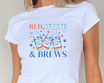 May include: White t-shirt with a red, white, and blue graphic design. The graphic features three cans of beer with the text "Red, White & Brews".