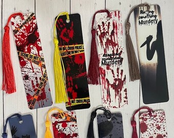 May include: Set of ten bookmarks with a murder mystery theme. The bookmarks feature different designs with blood splatter, crime scene tape, and text such as "Reading something murdery" and "In my thriller era". Each bookmark has a tassel.