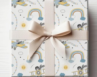 May include: White gift wrap with a repeating pattern of airplanes, rainbows, suns, and stars. The text "Happy Birthday" is printed on a banner.
