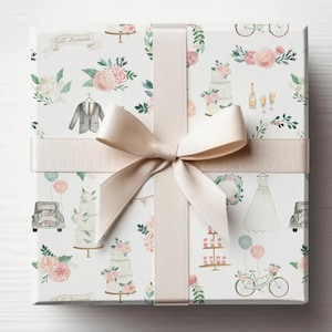 K&ouml;nnte beinhalten: Wei&szlig;e Geschenkpapier mit einem sich wiederholenden Muster aus Hochzeitsmotiven. Die Illustrationen zeigen eine Hochzeitstorte, ein Fahrrad, einen Blumenstrau&szlig;, einen Anzug, ein Hochzeitskleid, eine Champagnerflasche und den Text "Just Married".