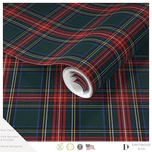 Può includere: Un rotolo di carta da parati con un motivo a quadri tartan in verde scuro, rosso, blu e bianco. Il design è composto da linee orizzontali e verticali che si intersecano formando una griglia classica. Il rotolo è parzialmente srotolato.
