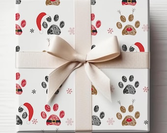 May include: A white gift box with a beige ribbon and bow. The box is wrapped in Christmas wrapping paper with a paw print and Santa hat design.