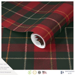 Può includere: Un rotolo di carta da parati con un motivo a quadri verde scuro e rosso con sottili linee dorate che si incrociano. La superficie ha una finitura testurizzata. Il testo include Non Toxic, USA Sourced & Printed, Hand Designed e Driftwood & Co.