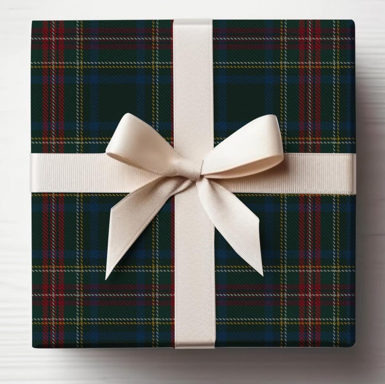 Pu&ograve; includere: Una scatola regalo quadrata avvolta in carta con motivo tartan verde scuro, blu e rosso con sottili linee a griglia gialle. La scatola &egrave; legata con un liscio nastro di raso color crema che forma un fiocco centrato sulla parte anteriore.