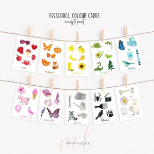May include: A collection of watercolour flashcards for early years education, each card displaying a colour and related images. The cards are suspended on a string with wooden pegs. Text on the cards includes colour names such as "red," "orange," and "blue."