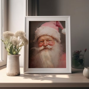 May include: A framed painting of Santa Claus with a pink hat and white beard. He is smiling and wearing a pink coat.
