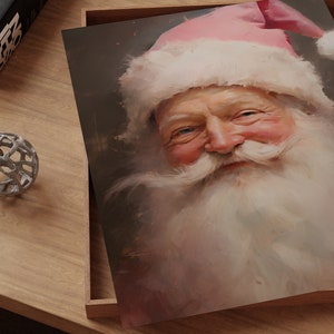 May include: A close-up portrait of Santa Claus with a pink hat and white beard. He is smiling and looking directly at the viewer.