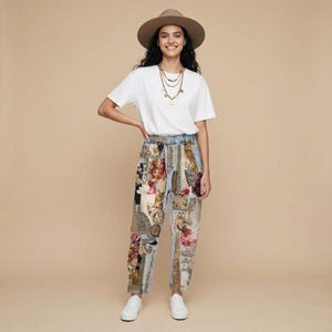 May include: A wide-brimmed tan felt hat, a plain white short-sleeved t-shirt, a multi-layered gold chain necklace, and light-wash denim pants featuring a patchwork design of various floral, paisley, and textured fabric patterns in muted tones.
