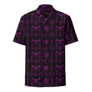 May include: A black short-sleeve button-down shirt featuring a repeating pattern of bright pink winged gargoyle figures and vertical geometric symbols. The shirt has a classic collar and a straight hem, showcasing a bold, high-contrast design.