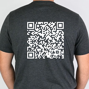 May include: A dark gray t-shirt with a white QR code printed on the back.