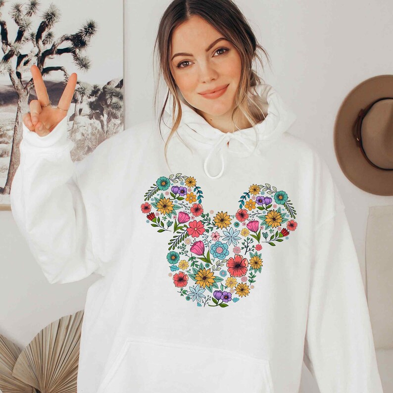 a woman wearing a white mickey mouse hoodie