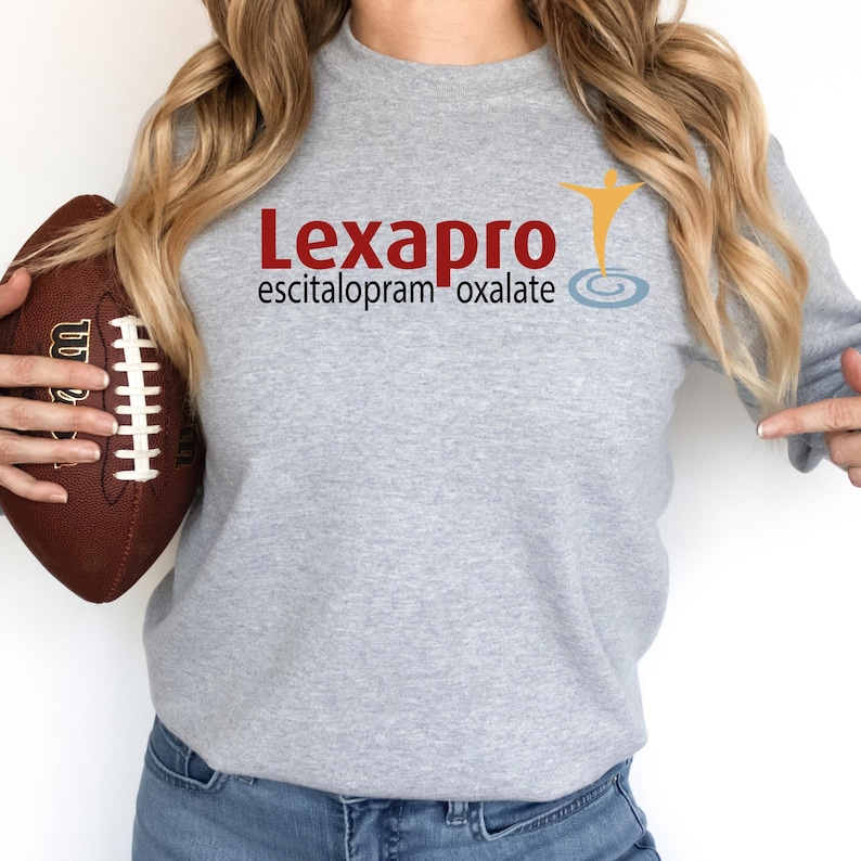 a woman is holding a football and wearing a sweatshirt