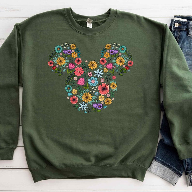 a green sweatshirt with a mickey mouse design on it