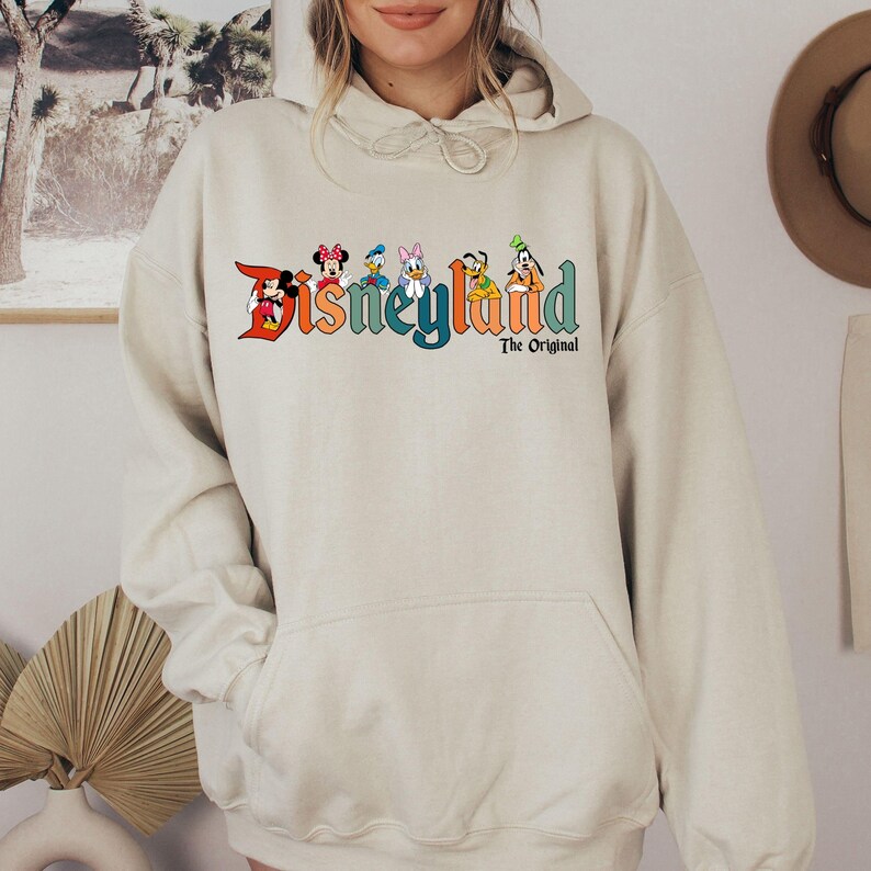a woman wearing a white disney land hoodie
