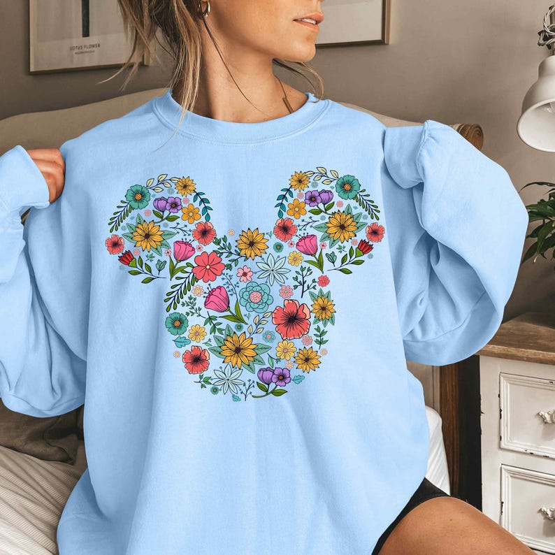 a woman wearing a blue mickey mouse sweatshirt