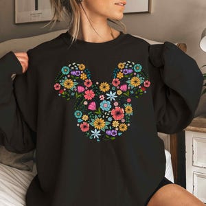 a woman wearing a black mickey mouse shirt