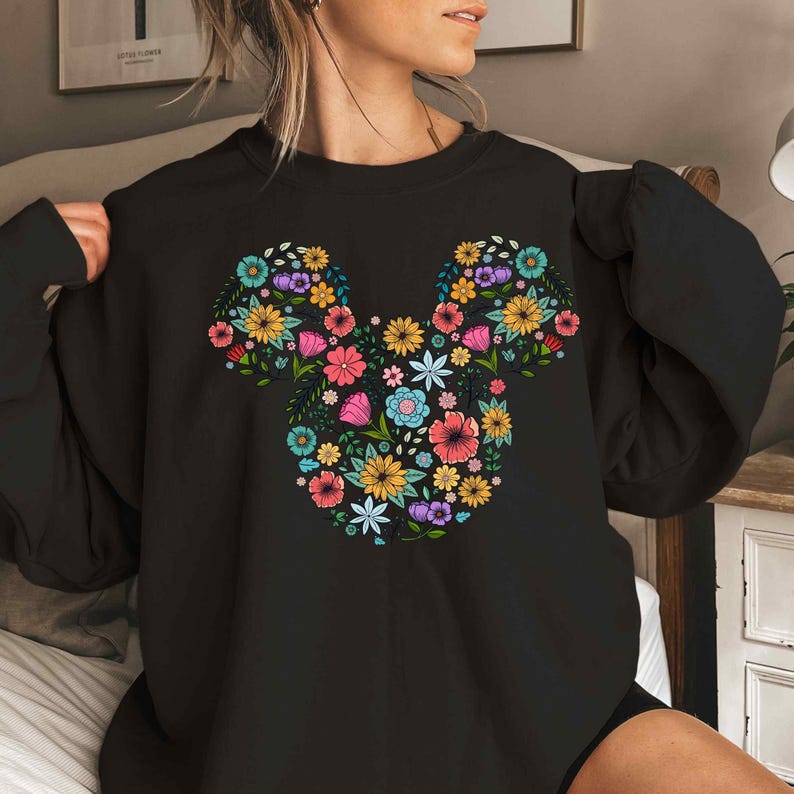 a woman wearing a black mickey mouse shirt