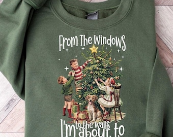 May include: Green sweatshirt with a vintage Christmas illustration of children decorating a tree. The text reads "From the windows to the walls I'm about to deck these halls."